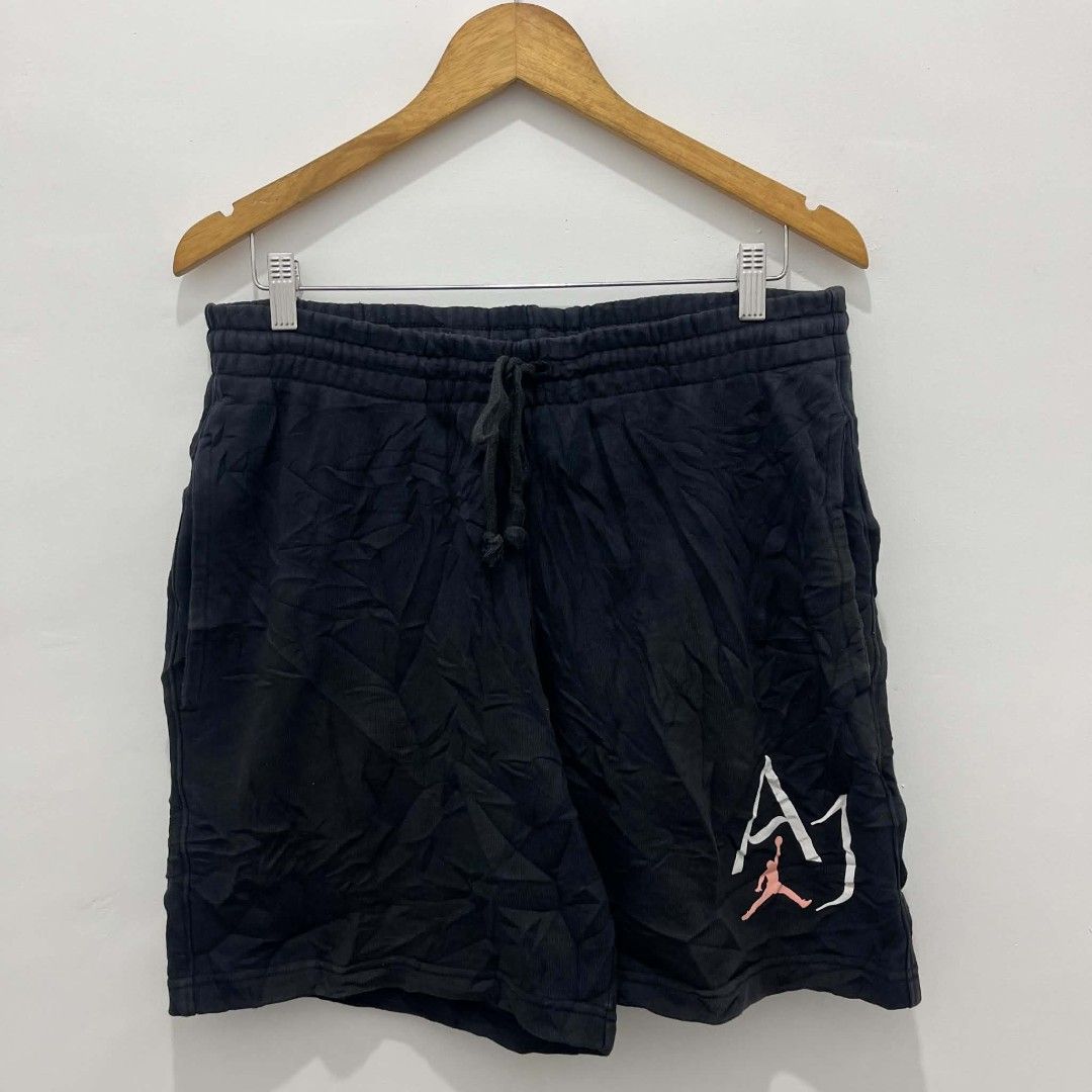 Jordan Black Sweat Shorts (Category: Shorts) located in Santa Rita. Submitted by papagabs01 (Listing ID 1465675615, Image 2). Description: Waistline : 33-38 Length : 18 Leg hole : 13 9.5/10 Color Rate ✨ No pinhole No Cracks print - Brand: Jordan - Color: Black with pink Jumpman logo and big AJ graphic - Size: Large (Style Code: DM1873-010) - Material: Comfortable cotton blend fleece - Features: Elastic waistband with drawstring and two side pocke