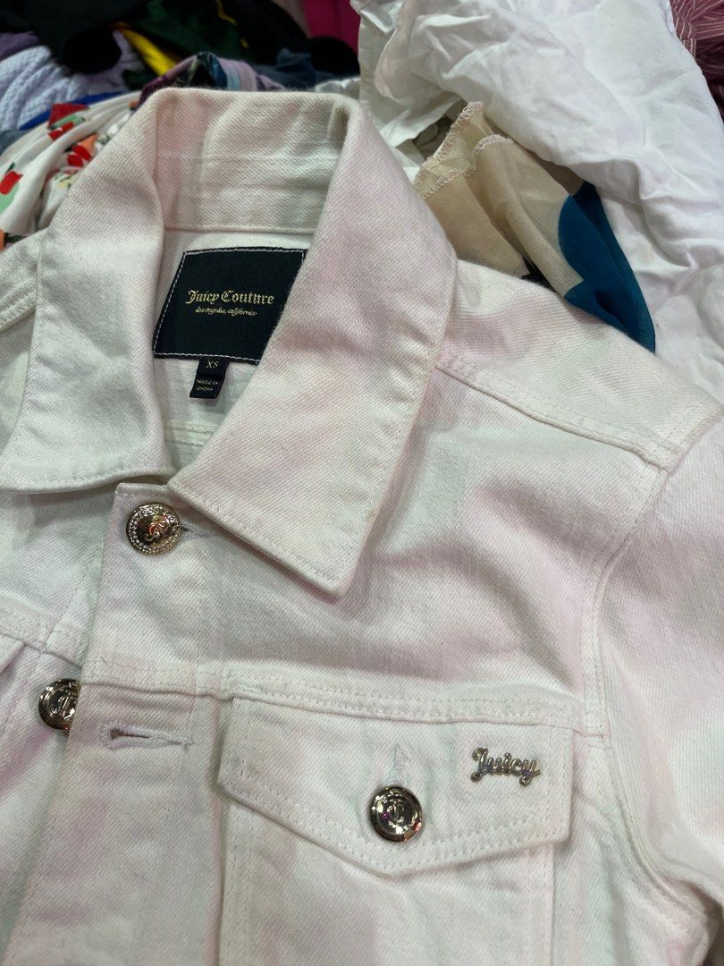 Juicy Couture White Denim Jacket with Rhinestone Logo (Category: Coats, Jackets and Outerwear) located in Caloocan City. Submitted by pumarenluc79160 (Listing ID 1465719455, Image 3). Description: - Brand: Juicy Couture - Size: XS - Color: White - Details: Gold rhinestone buttons on front and cuffs - Back: Eye-catching rhinestone 'Juicy' logo - Pockets: Two button-flap chest pockets - Fit: Classic cropped denim jacket style, ideal for layering - 