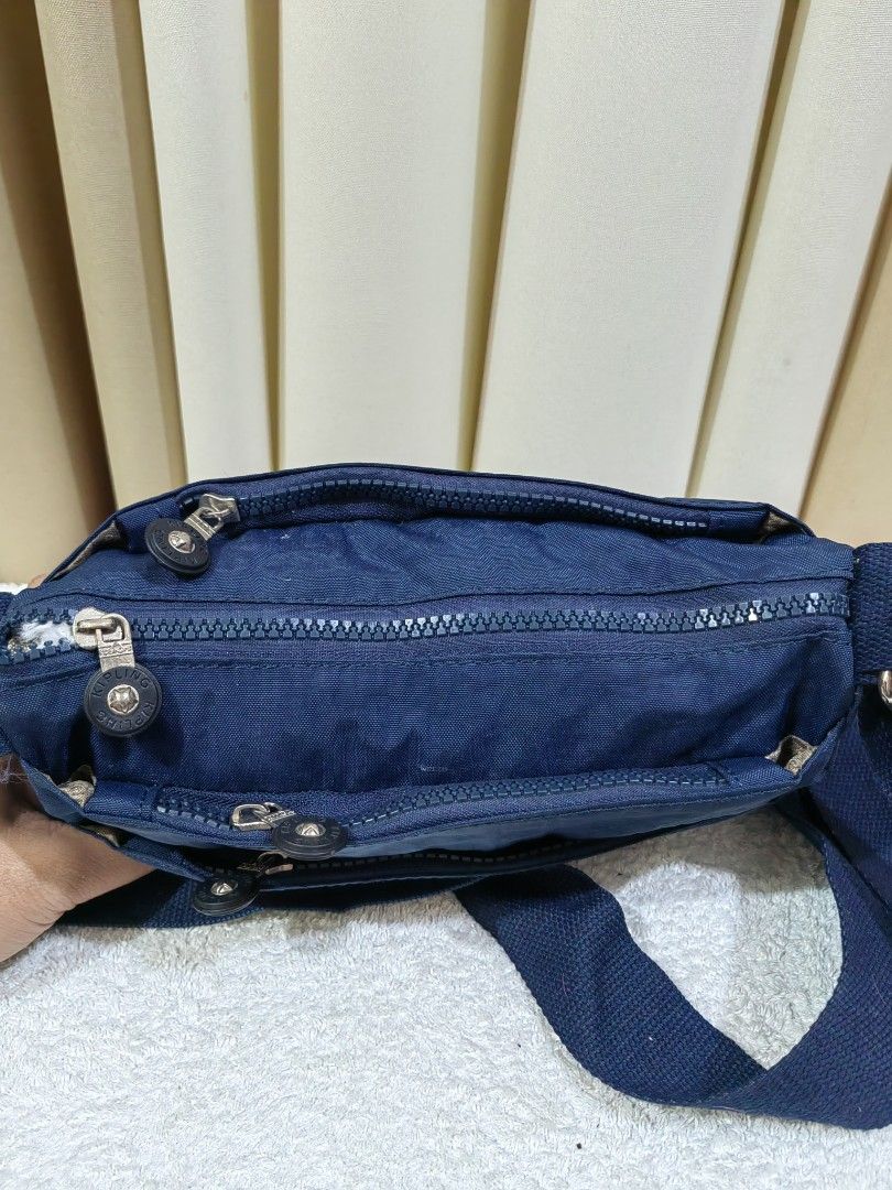 Kipling blue crossbody bag (Category: Cross-body Bags) located in Makati City. Submitted by prelovedtreatedwithlove (Listing ID 1465622471, Image 3). Description: - Kipling blue crossbody bag - Durable and lightweight nylon material - Multiple exterior zipper pockets for easy organization - Comfortable adjustable blue shoulder strap - Clean interior lined with patterned fabric plus an extra zip pocket - issue: hardware rust. Last pic for referenc