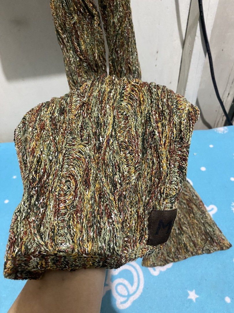 Knitted Winter Scarf Multi-color Earth Tones (Category: Scarves) located in Manila. Submitted by resi.diaz (Listing ID 1465672260, Image 2). Description: - Approx: 68 x 8 inches - Style: Thick cable-knit winter scarf - Colors: Multi-color earth tones (olive green, brown, mustard) - Details: Features a soft textured pattern and a small brown leather patch with a letter logo - Condition: Excellent, no damage or loose threads - Benefit: Keeps you wa