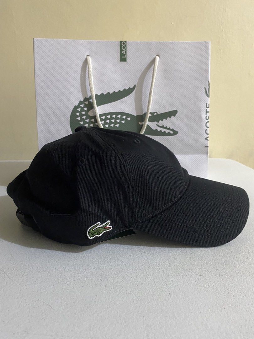 Lacoste Black Cap with Embroidered Logo 200 ( Decluttering ) (Category: Caps & Hats) located in Quezon City. Submitted by joelds (Listing ID 1465585401, Image 1). Description: - Brand: Lacoste - Color: Classic Black - Logo: Iconic embroidered green crocodile on the side - Design: Curved brim with embroidered eyelets for ventilation - Style: Clean, simple, and easy to pair with everyday casual outfits.