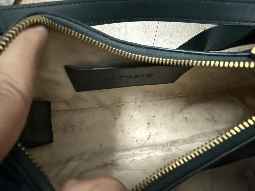 Lacoste Black Monogram Crescent Crossbody Bag (Category: Cross-body Bags) located in Pasig City. Submitted by cvj25 (Listing ID 1465686070, Image 2). Description: - Brand: Lacoste Original Price: 15,000 - Style: Crescent crossbody bag in classic black - Design: Embossed geometric monogram pattern with gold-toned hardware - Strap: Adjustable fabric strap for comfortable wear - Interior: Cream-coloured lining with a branded leather inner pocket - C