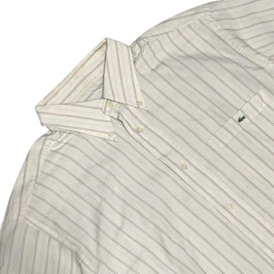 LACOSTE | Short Sleeve Striped Button Down Shirt Size 41 (Category: Tshirts & Polo Shirts ) located in Imus. Submitted by thealfa8archive (Listing ID 1465744274, Image 2). Description: - Brand: Lacoste - Style: Short-sleeve button-down shirt - Color/Pattern: Cream base with thin multicolored stripes (yellow, blue, red, grey) - Size: 41 (Tag at inner collar) - Features: Button-down collar, single chest pocket with iconic embroidered green crocodil