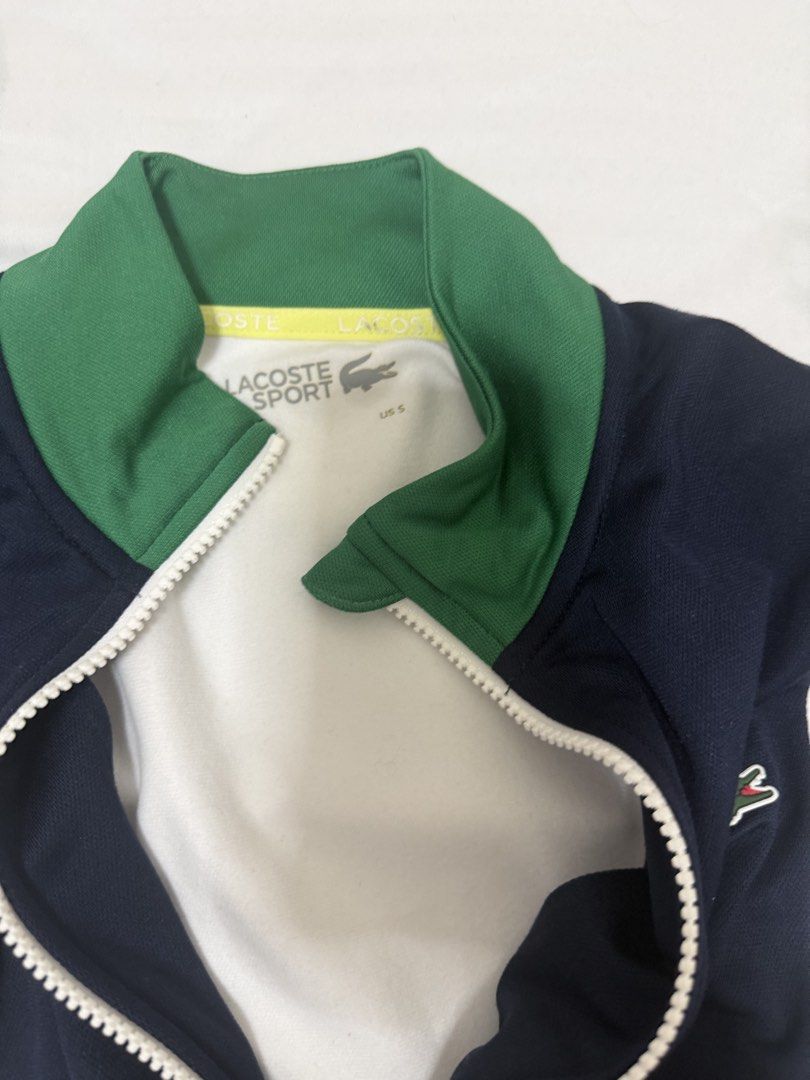 Lacoste Sport Zip Jacket (Category: Coats, Jackets and Outerwear) located in Santa Rosa. Submitted by decluttering_. (Listing ID 1465699886, Image 3). Description: AUTHENTIC - Brand: Lacoste Sport - Design: Navy, white, and green colorblock with bold sleeve lettering tape - Features: Full zip front, stand collar, ribbed green cuffs and hem - Size: US Small - Condition: Clean overall, great for gym or casual wear.