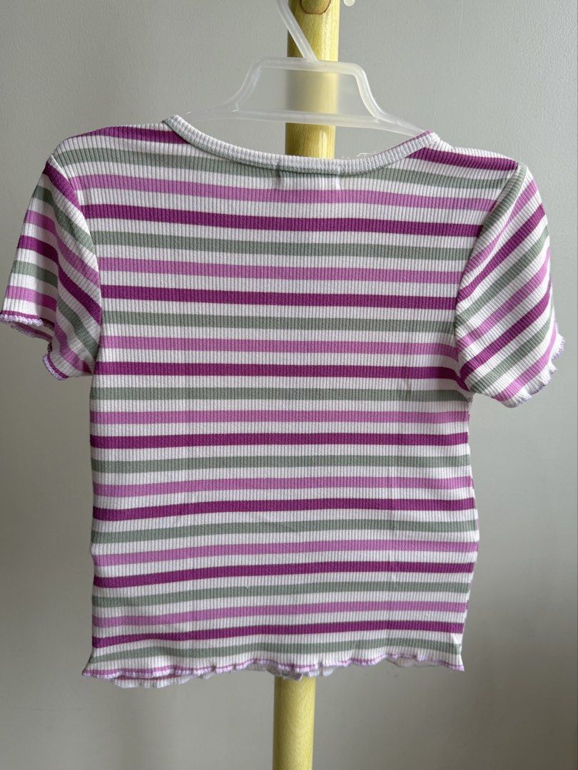 Lemon Kiss Striped Ribbed Button Crop Top (Category: Babies & Kids Fashion) located in Quezon City. Submitted by warmrabbit_414908 (Listing ID 1465594627, Image 2). Description: - Brand: Lemon Kiss - Design: White with purple and green horizontal stripes - Material: Textured ribbed fabric - Details: Round neckline, functional brown buttons down the front, lettuce hem on sleeves and bottom - Fit: Short/cropped length.