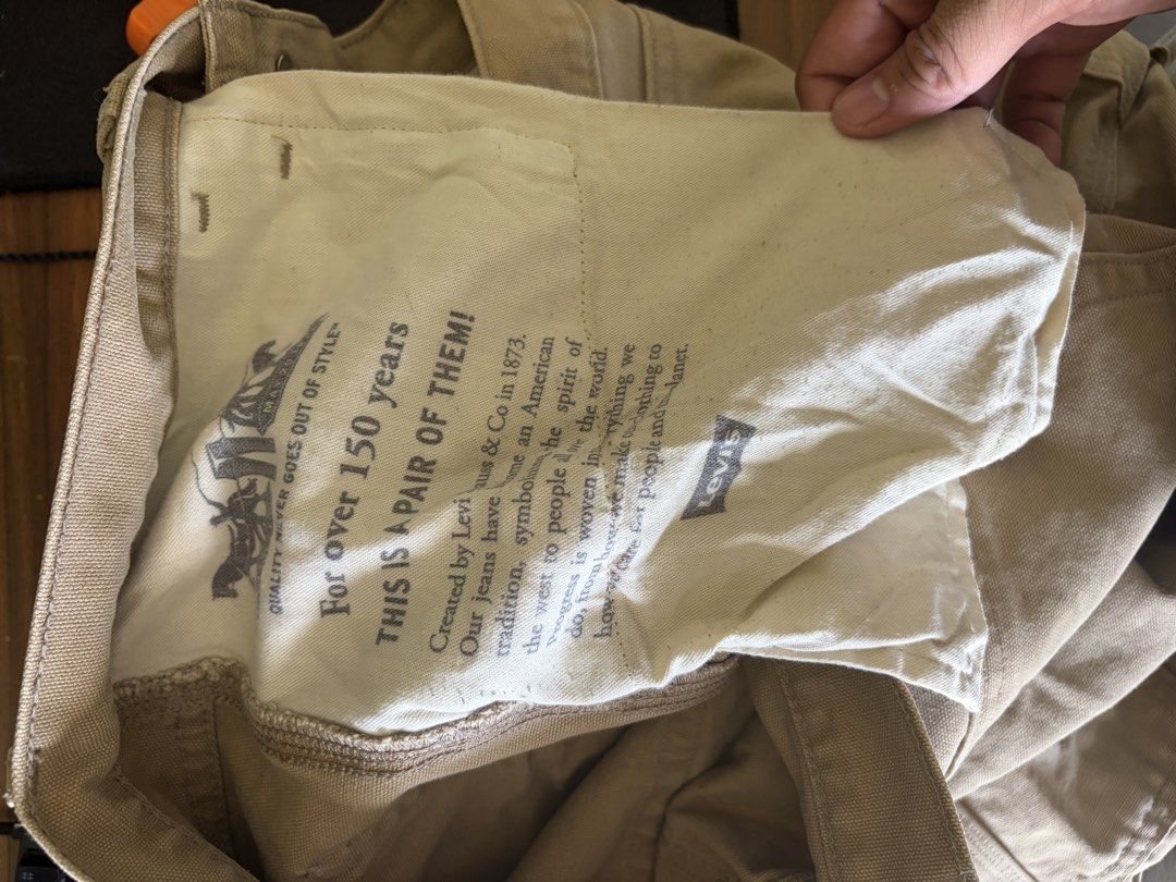 Levi's Canvas Utility Work Pants Beige Distressed Knees (Category: Jeans) located in Taytay. Submitted by newphoenix.31abd6 (Listing ID 1465588407, Image 2). Description: - Brand: Levi's - Color: Tan - Style: Utility work pants / carpenter style with relaxed straight leg - Details: Double knees with distressing, side utility pockets, and iconic red tab - Special Feature: Inner pocket lining features Levi's 150 years text print - Material: Durable