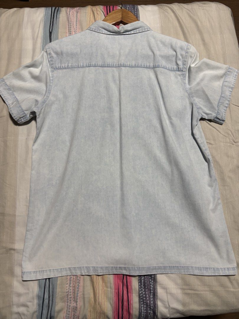Light blue denim short sleeve button up shirt (Category: Shirts) located in Quezon City. Submitted by declutter_incorporated (Listing ID 1465693570, Image 3). Description: - Style: Casual short sleeve denim shirt - Color/Wash: Light wash - Details: Classic button-down front with standard collar - Condition: Clean, no major flaws noticed - Pairing: Easy to match with shorts or jeans.
