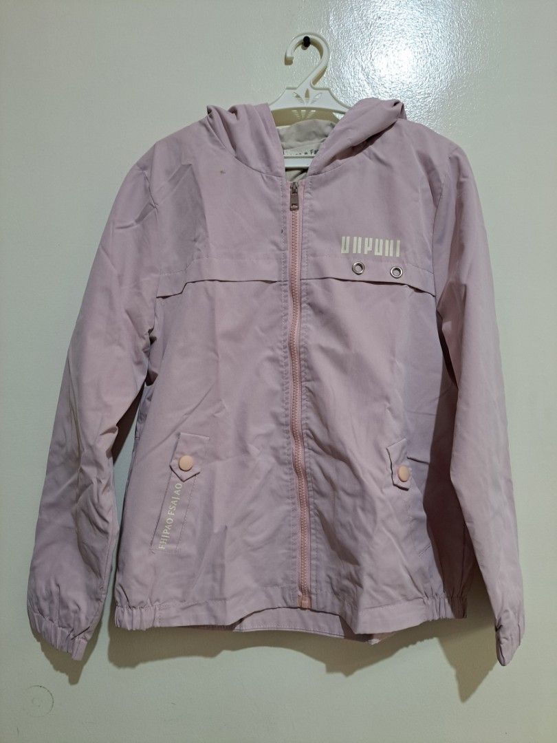 Light Pink Zip Up Hooded Windbreaker Jacket (Category: Coats, Jackets and Outerwear) located in Manila. Submitted by yselles__ (Listing ID 1465604315, Image 1). Description: - Color: Light pink - Style: Zip-up hoodie with smooth, lightweight inner lining - Features: Front pockets with button details, elastic cuffs and hem - Details: Cute print on the chest and unique back strap design - Condition: Clean, worn just a few times.