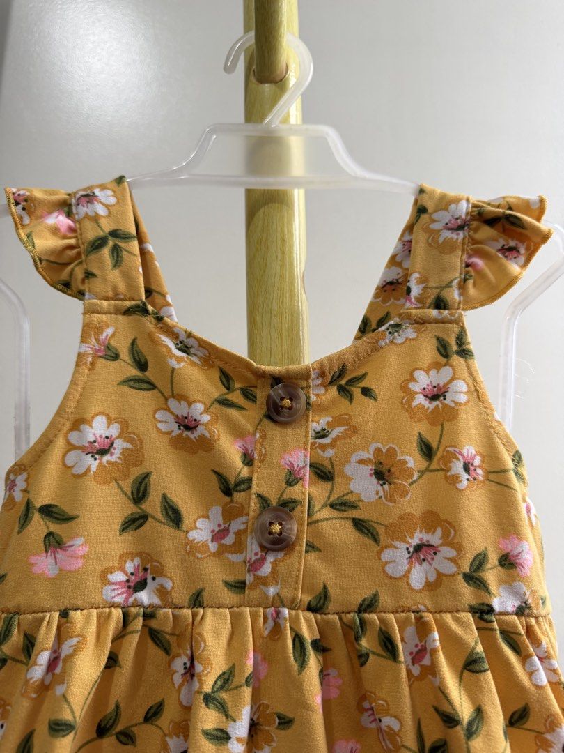 Little Lass Yellow Floral Top (Category: Babies & Kids Fashion) located in Quezon City. Submitted by warmrabbit_414908 (Listing ID 1465597191, Image 1). Description: - Brand: Little Lass - Design: Yellow with white/pink flowers and green leaves - Features: Ruffle shoulder straps, functional front buttons, gathered waist, and flared ruffled hem - Condition: Brand tag attached inside neckline - Material: Lightweight and comfortable for toddlers.