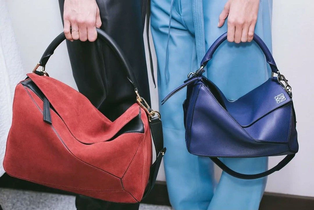 Loewe Puzzle Bag Suede Red (Category: Luxury Bags & Wallets) located in Quezon City. Submitted by mcenon35 (Listing ID 1465693740, Image 2). Description: - Brand: Loewe Puzzle Bag - Material: Rich red suede with black leather handle and strap - Design: Iconic geometric panel construction (folds completely flat) - Hardware: Gold-tone throughout with top zip closure and leather pull - Details: Subtle embossed Anagram logo on the corner - Interior: 
