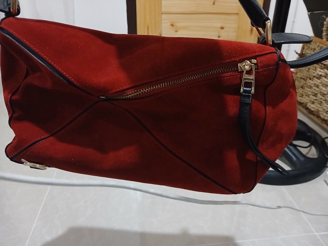 Loewe Puzzle Bag Suede Red (Category: Luxury Bags & Wallets) located in Quezon City. Submitted by mcenon35 (Listing ID 1465693740, Image 3). Description: - Brand: Loewe Puzzle Bag - Material: Rich red suede with black leather handle and strap - Design: Iconic geometric panel construction (folds completely flat) - Hardware: Gold-tone throughout with top zip closure and leather pull - Details: Subtle embossed Anagram logo on the corner - Interior: 