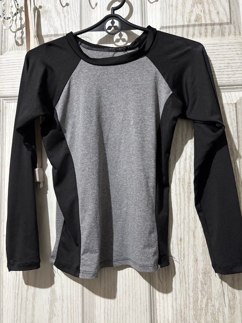 Long sleeve grey and black rash guard top (Category: Rash guard) located in Bautista. Submitted by abgciaa (Listing ID 1465622617, Image 1). Description: - Versatile long sleeve athletic top for workouts, swimming, or surfing - Stylish grey heathered front panel with solid black raglan sleeves and side panels - Comfortable round neck design with a standard fit - Highly stretchable and flexible fabric for maximum movement.