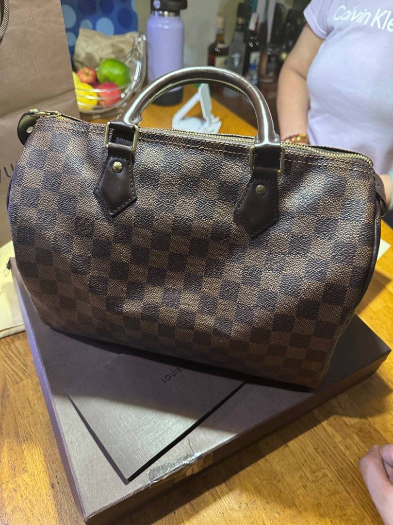 Louis Vuitton Damier Ebene Speedy 30 Handbag (Category: Luxury Bags & Wallets) located in Manila. Submitted by graaaaannny (Listing ID 1465601416, Image 3). Description: - Brand: Louis Vuitton - Model: Damier Ebene Handbag Speedy 30 - Color/Pattern: Brown Checkered Canvas - Hardware: Gold-tone - Handles: Double top handles - Customization: Subtle L.S. initials stamped on the front leather tab - Condition: Clean interior and corners, excellent ove
