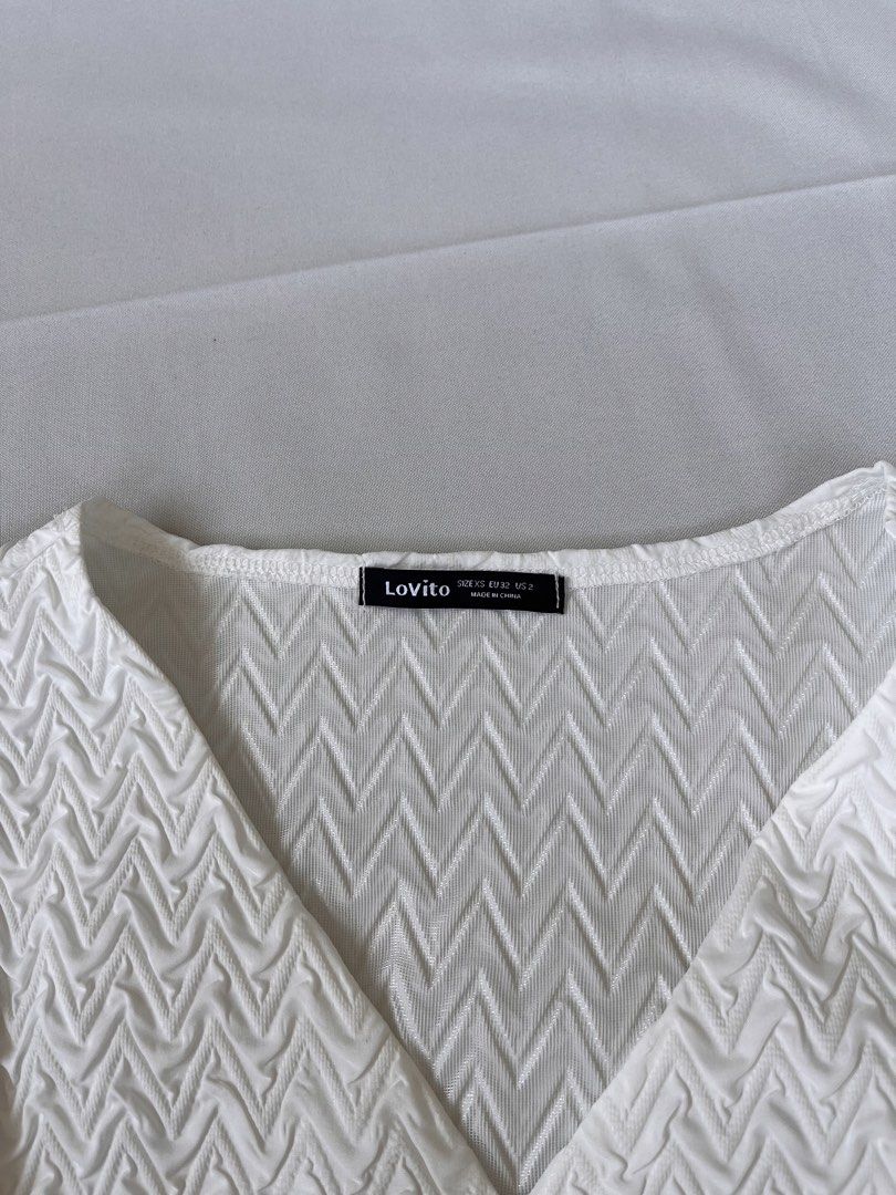 Lovito White Textured V-Neck Blouse Size XS (Category: Blouses) located in Tarlac. Submitted by haleyjames_scott (Listing ID 1465595006, Image 2). Description: • Size: XS on tag (mej maluwag sa akin so I think S safest size!) •Only used once •Buttons working.