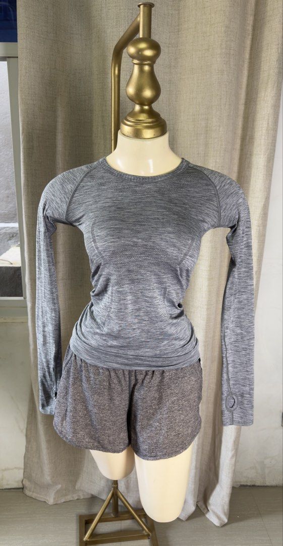 Lululemon Grey swiftly tech longsleeves (Category: Activewear) located in Lemery. Submitted by bbucket (Listing ID 1465601267, Image 3). Description: - Brand: Lululemon - Color: Heathered Grey - Material: Seamless, body-hugging ribbed fabric - Design: Round neckline, long sleeves with thumbholes - Detail: Small reflective white logo near the back collar - Condition: Excellent, lightly used - Perfect for: Gym, running, yoga, or everyday athleisure