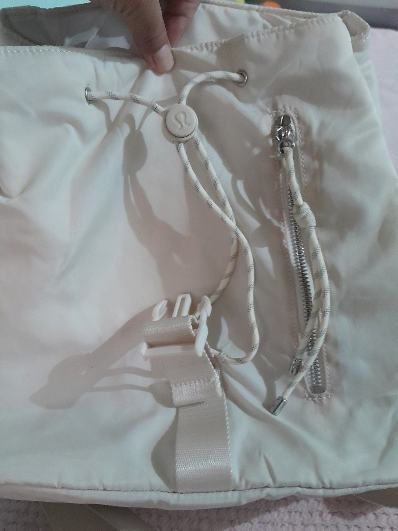 Lululemon Off-White Nylon Backpack O/S 30x12cm (Category: Backpacks) located in Rizal. Submitted by bravefish_da429e (Listing ID 1465665878, Image 3). Description: - Brand: Lululemon - Color: Off-white - Material: 100% recycled nylon (lightweight) - Dimensions: 30 x 12 cm (One Size) - Closure: Front flap with buckle and cinch drawstrings - Pockets: Front zippered pocket and inner zip pocket - Straps: Adjustable shoulder straps - Condition: Clean,