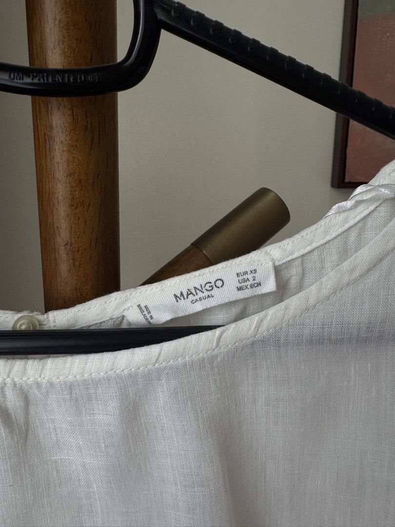 Mango Casual White Blouse Linen (Category: Blouses) located in Pasig City. Submitted by kutleyn (Listing ID 1465670294, Image 2). Description: - Brand: Mango Casual - Size: EUR XS / USA 2 - Color: Classic White - Material: Lightweight, subtly textured fabric - Design: Half-length bell sleeves, round neckline with back button closure - Style: Versatile for casual outings or office wear - Condition: Excellent pre-loved / like new.