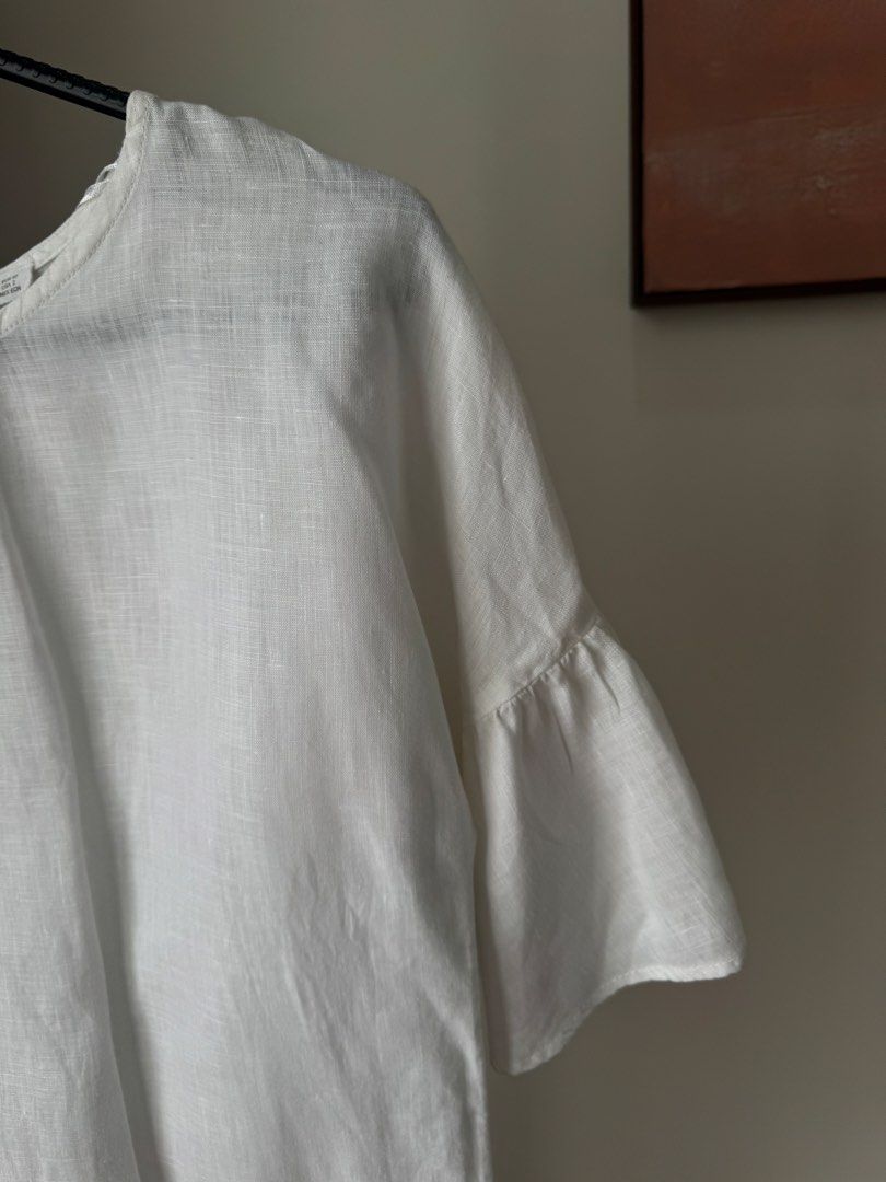 Mango Casual White Blouse Linen (Category: Blouses) located in Pasig City. Submitted by kutleyn (Listing ID 1465670294, Image 3). Description: - Brand: Mango Casual - Size: EUR XS / USA 2 - Color: Classic White - Material: Lightweight, subtly textured fabric - Design: Half-length bell sleeves, round neckline with back button closure - Style: Versatile for casual outings or office wear - Condition: Excellent pre-loved / like new.
