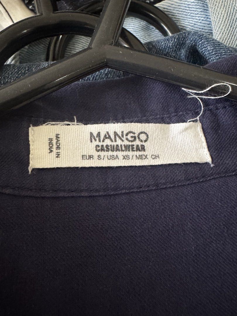 Mango Casualwear Navy Blue Sleeveless Button-Down Blouse (Category: Sleeveless) located in Pasig City. Submitted by kutleyn (Listing ID 1465672491, Image 3). Description: - Brand: Mango - Color: Navy Blue - Size: EUR S / USA XS - Material: Lightweight, breathable fabric - Design: Sleeveless, collar, V-neck, button-down front - Styling: Versatile; wear it loose or tied in a knot at the front - Condition: Great for warm weather and everyday wear.