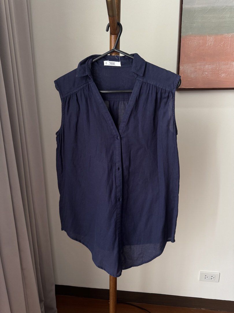 Mango Casualwear Navy Blue Sleeveless Button-Down Blouse (Category: Sleeveless) located in Pasig City. Submitted by kutleyn (Listing ID 1465672491, Image 1). Description: - Brand: Mango - Color: Navy Blue - Size: EUR S / USA XS - Material: Lightweight, breathable fabric - Design: Sleeveless, collar, V-neck, button-down front - Styling: Versatile; wear it loose or tied in a knot at the front - Condition: Great for warm weather and everyday wear.