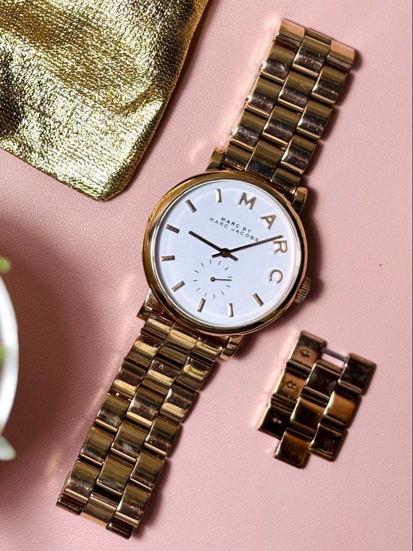 Marc by Marc Jacobs Gold Watch (Category: Women's Watches) located in Sorsogon. Submitted by mascarinli36387 (Listing ID 1465588376, Image 3). Description: - Brand: Marc by Marc Jacobs - Color: Elegant gold-tone - Dial: White with chic gold markers and second sub-dial - Band: Metal link bracelet (normal wear on band and clasp from regular use) - Inclusions: Extra links included as seen in photos - Condition: Well-loved and fully functional Price 