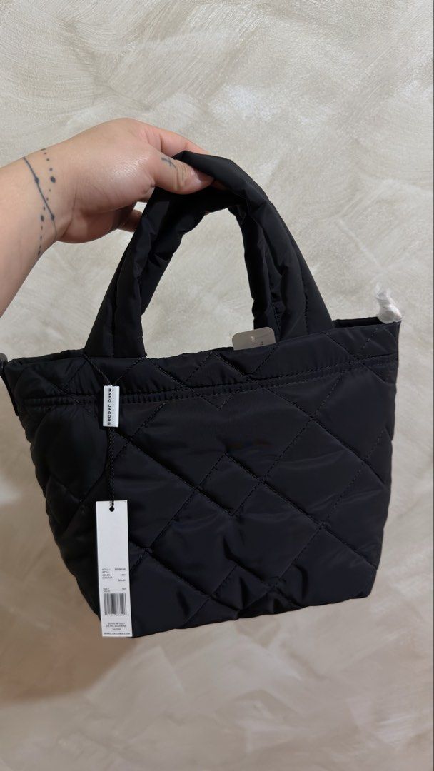 Marc Jacobs Quilted Nylon Mini Tote Bag Black (Category: Cross-body Bags) located in Las Pinas. Submitted by mharjrahm (Listing ID 1465596855, Image 2). Description: - Brand: Marc Jacobs - Style: Quilted tote bag in lightweight black nylon - Details: Puffy top handles, gold hardware, front logo plaque - Condition: Brand new with tags (BNWT) - Price: Retail value at $225.00 - Features: Spacious main compartment, versatile daily style - Perfect for