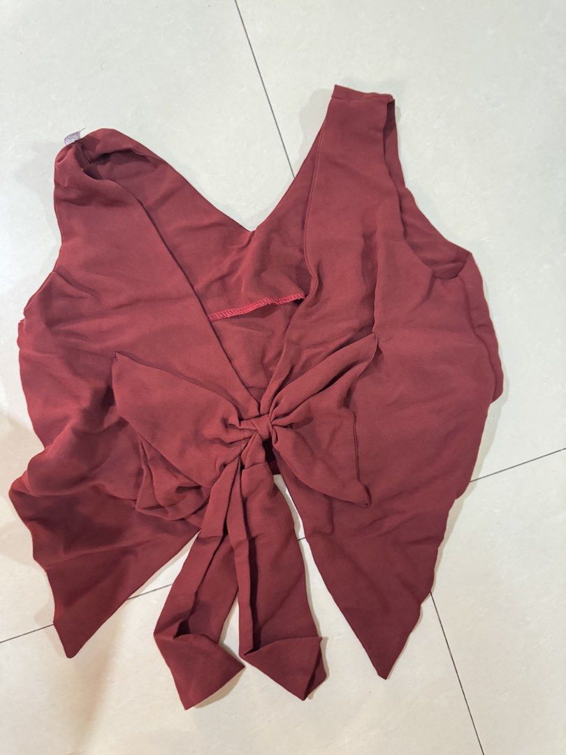 Maroon V-Neck Crop Top with ribbon bow (Category: Blouses) located in Quezon City. Submitted by sweetlyluxe (Listing ID 1465601517, Image 2). Description: - Color: Maroon - Style: Sleeveless crop top with V-neckline - Details: Chic ribbon bow knot with draped fabric - Fabric: Lightweight and unlined (great for layering or warm weather).