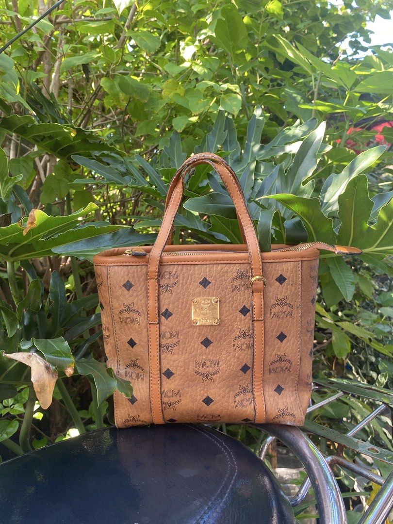 MCM Cognac Visetos Monogram Small Tote Bag (Category: Luxury Bags & Wallets) located in Manila. Submitted by cdb_22 (Listing ID 1465597922, Image 1). Description: - Brand: MCM - Style: Monogram Leather Tote Bag - Color: Brown with tan dual top handles - Hardware: Gold-tone with front metal plaque - Closure: Secure zip-top closure - Interior: Clean, spacious for daily essentials - Condition: Excellent, ready to use.