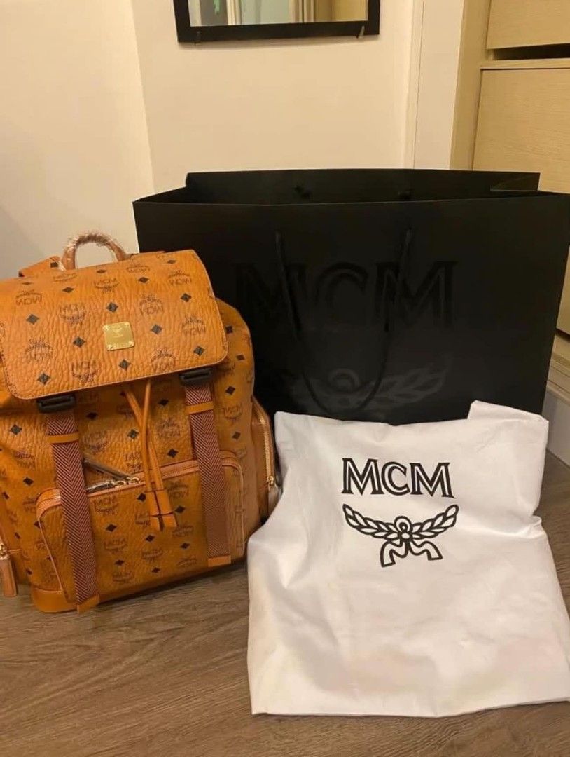 MCM Stark Cognac Visetos Monogram Backpack (Category: Backpacks) located in Paoay. Submitted by rvf1230 (Listing ID 1465664243, Image 2). Description: - Authentic MCM backpack in classic cognac brown Visetos monogram - Features secure buckled flap closure with drawstring, front zip pocket, and side pockets - Elegant gold-tone hardware (parts still wrapped in protective plastic) - Spacious interior, ideal for daily use - Includes original dust bag