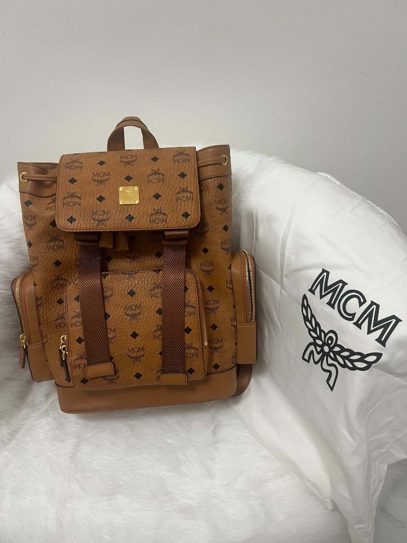 MCM Stark Cognac Visetos Monogram Backpack (Category: Backpacks) located in Paoay. Submitted by rvf1230 (Listing ID 1465664243, Image 3). Description: - Authentic MCM backpack in classic cognac brown Visetos monogram - Features secure buckled flap closure with drawstring, front zip pocket, and side pockets - Elegant gold-tone hardware (parts still wrapped in protective plastic) - Spacious interior, ideal for daily use - Includes original dust bag