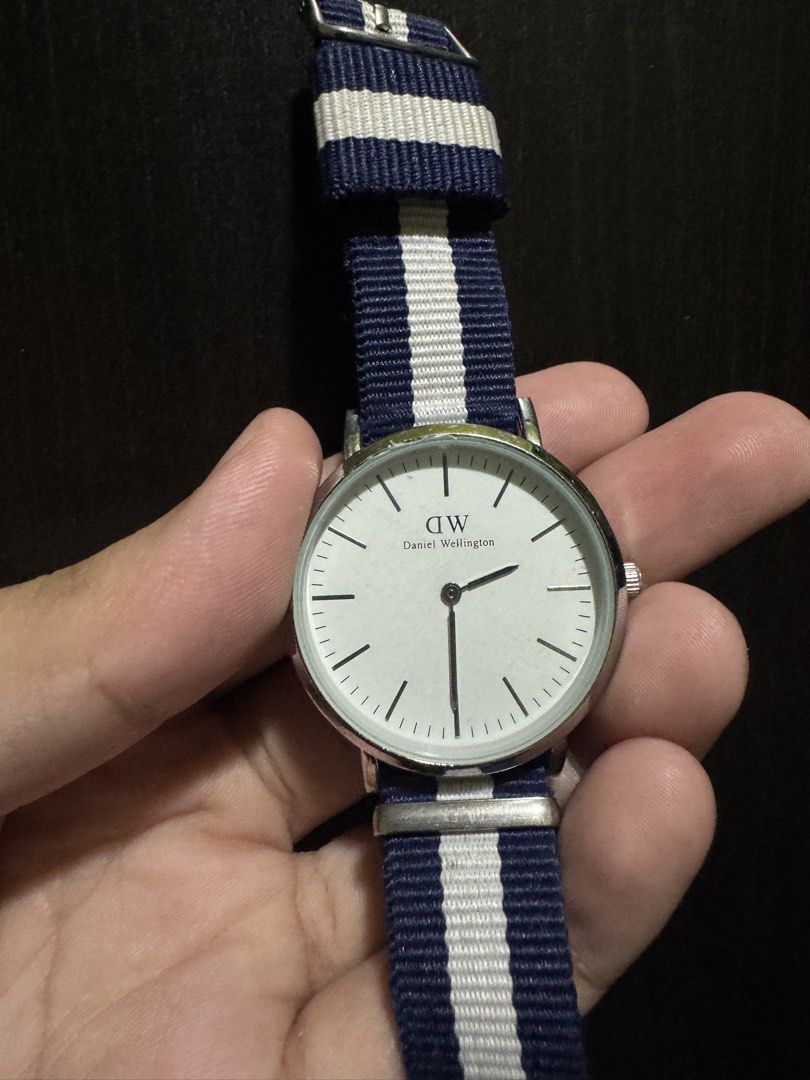 Men’s Glasgow Silver Daniel Wellington Watch (Category: Men's Watches) located in Manila. Submitted by pierce_120 (Listing ID 1465677390, Image 1). Description: - Brand: Daniel Wellington - Movement: Quartz (battery operated, keeps accurate time) - Dial: White dial with minimal markers and silver-tone case - Strap: Blue and white striped NATO fabric strap with a secure silver buckle - Water Resistance: 3ATM - Condition: Pre-loved with minor wear 