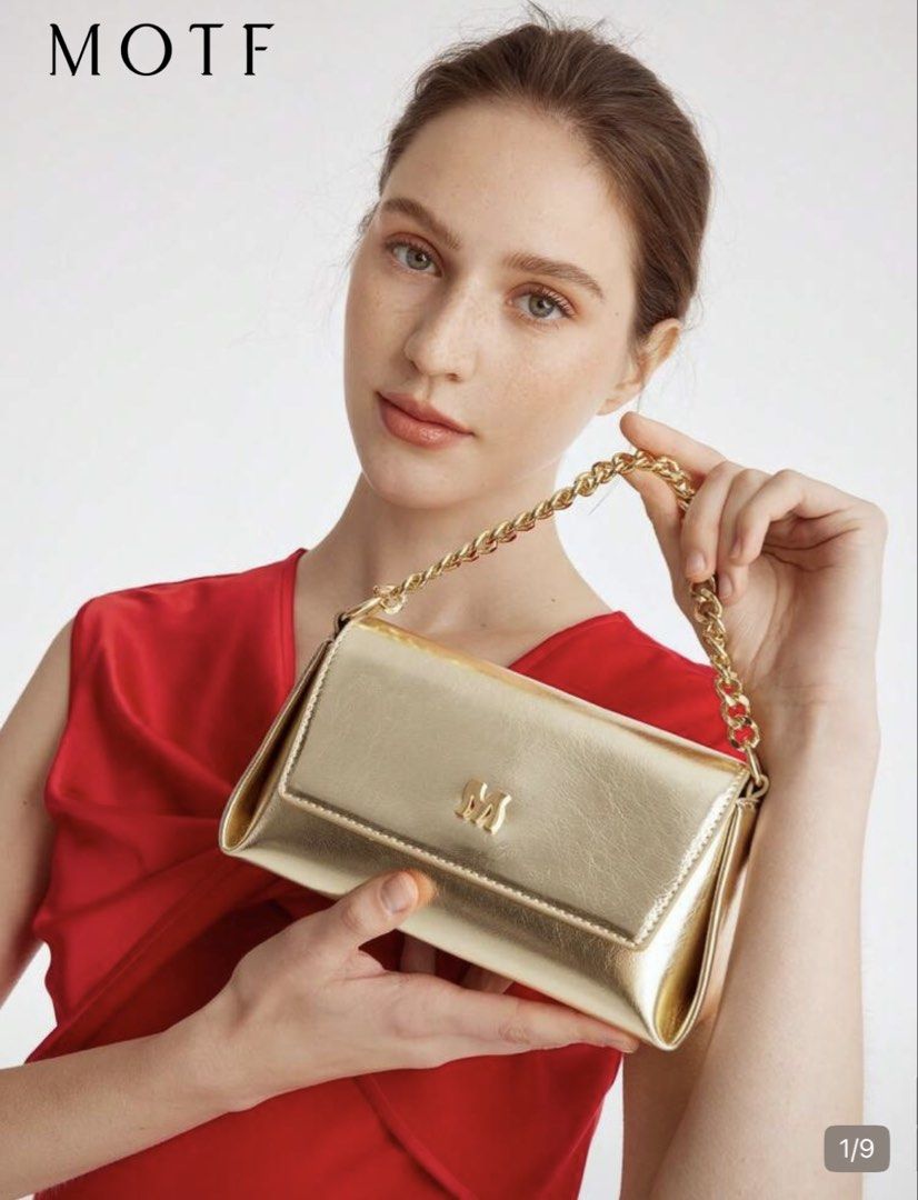 Metallic Gold Shoulder Bag with Chain Handle (Category: Purses & Pouches) located in Pasig City. Submitted by jnzmrq1003 (Listing ID 1465579496, Image 2). Description: - Color/Finish: Shiny metallic gold with a light-catching finish - Hardware: Distinctive 'M' logo on the front flap - Straps: Includes a chunky gold chain top handle and a matching long strap - Closure: Secure flap front closure - Condition: Clean surface, no scuffs seen - not used