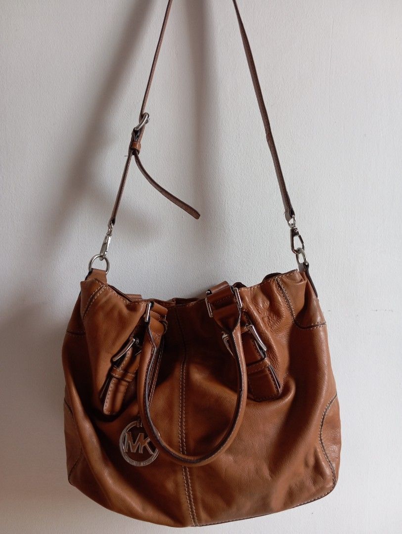 Michael Kors Brown Leather satchel Bag (Category: Luxury Bags & Wallets) located in Mandaluyong City. Submitted by famstuffs (Listing ID 1465643749, Image 2). Description: - Authentic Michael Kors tan leather bag - Dual top handles and a removable, adjustable crossbody strap for versatile wear - Stylish front buckle details with signature round MK logo charm - Secure zip-top closure - Spacious interior with MK logo lining, zippered compartments, 