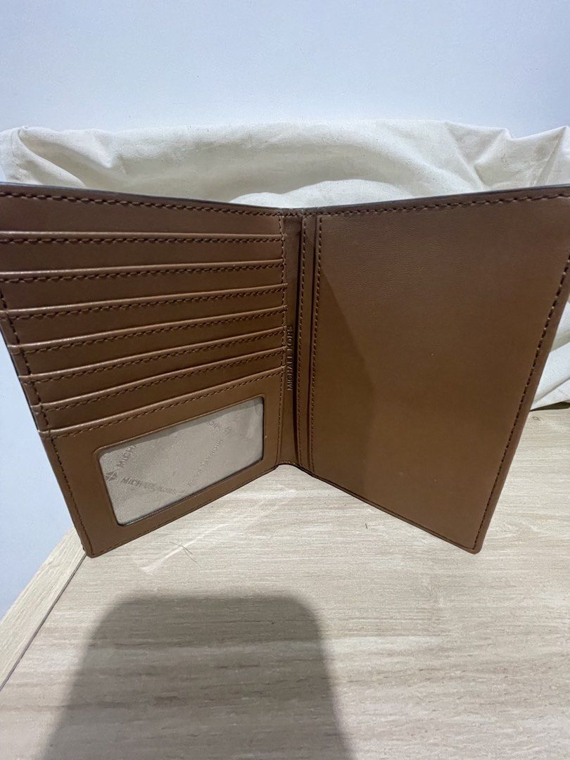 Michael Kors Brown Monogram Passport Wallet Holder (Category: Luxury Bags & Wallets) located in Cordova. Submitted by fiercedragon.47e450 (Listing ID 1465710521, Image 2). Description: - Authentic Michael Kors passport holder - Signature brown monogram print with gold foil logo - Tan interior lining with multiple card slots and clear ID window - Neat and clean stitching throughout - Keeps travel documents and cards stylishly organized.