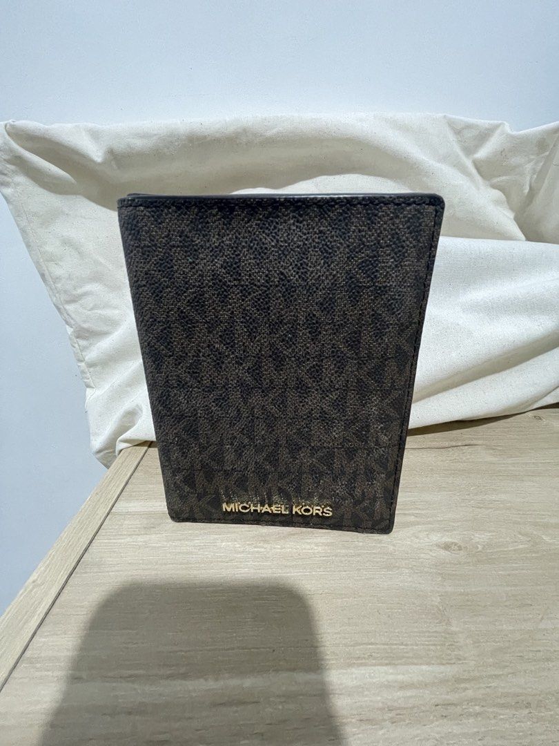 Michael Kors Brown Monogram Passport Wallet Holder (Category: Luxury Bags & Wallets) located in Cordova. Submitted by fiercedragon.47e450 (Listing ID 1465710521, Image 1). Description: - Authentic Michael Kors passport holder - Signature brown monogram print with gold foil logo - Tan interior lining with multiple card slots and clear ID window - Neat and clean stitching throughout - Keeps travel documents and cards stylishly organized.