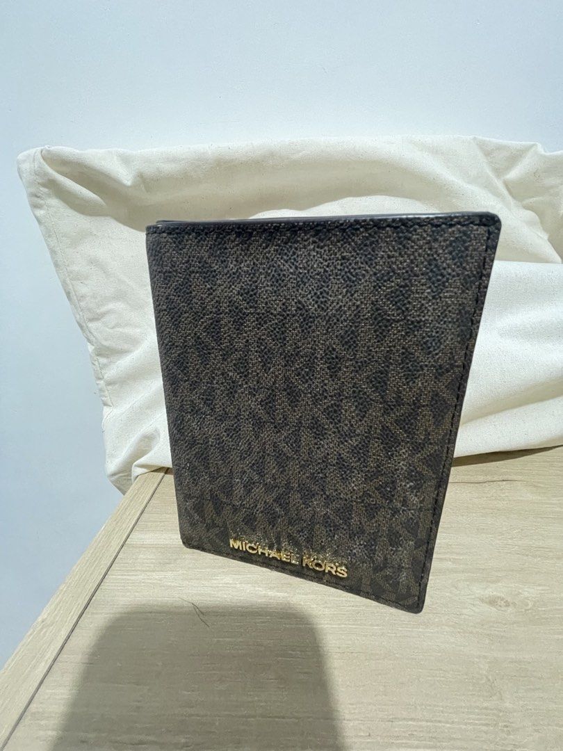 Michael Kors Brown Monogram Passport Wallet Holder (Category: Luxury Bags & Wallets) located in Cordova. Submitted by fiercedragon.47e450 (Listing ID 1465710521, Image 3). Description: - Authentic Michael Kors passport holder - Signature brown monogram print with gold foil logo - Tan interior lining with multiple card slots and clear ID window - Neat and clean stitching throughout - Keeps travel documents and cards stylishly organized.