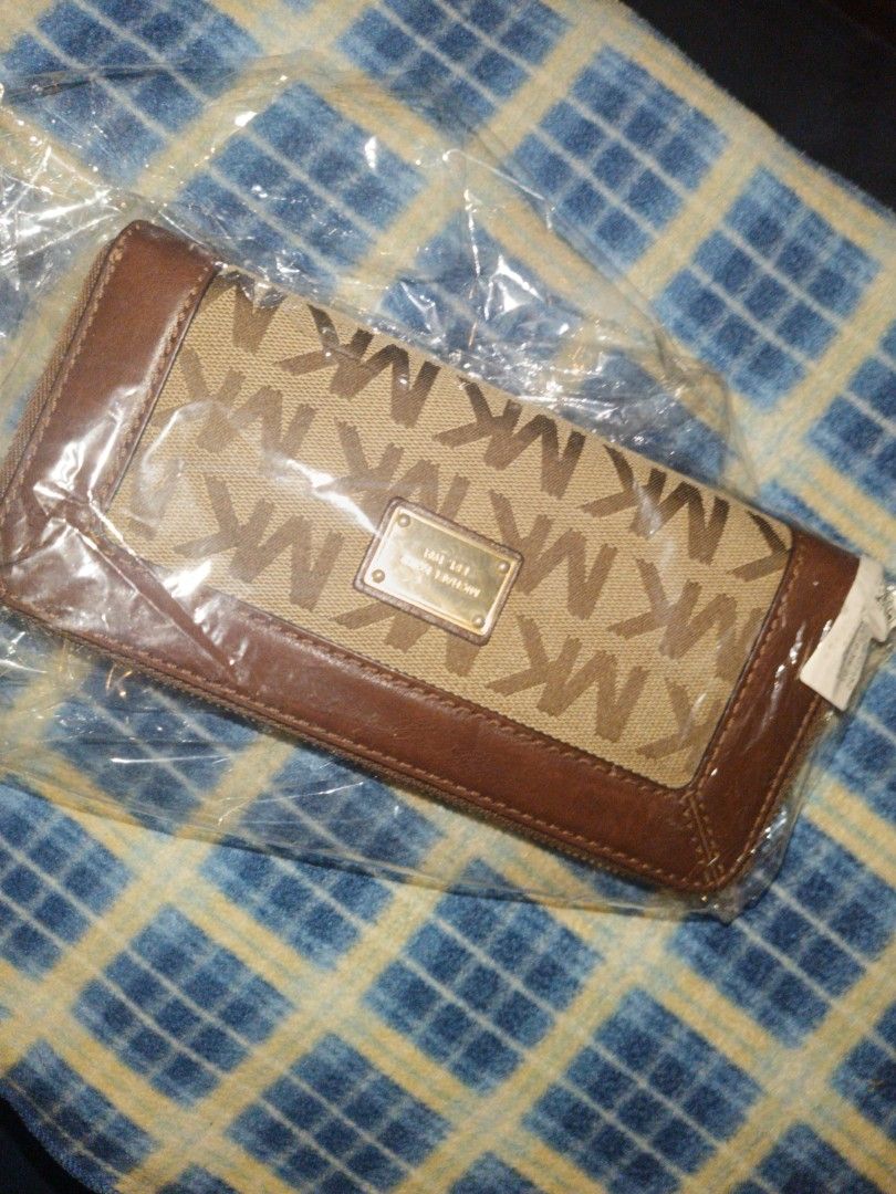 Michael Kors MK Monogram Brown Leather Zip Around Wallet (Category: Luxury Bags & Wallets) located in Baguio. Submitted by valenzuela.jc (Listing ID 1465699606, Image 1). Description: Sourced from Canada - Brand: Michael Kors - Design: Classic brown monogram print with solid brown leather trim and gold-tone hardware - Closure: Smooth zip-around action - Interior: Multiple card slots, slip pockets, and a secure zippered coin compartment - Conditio