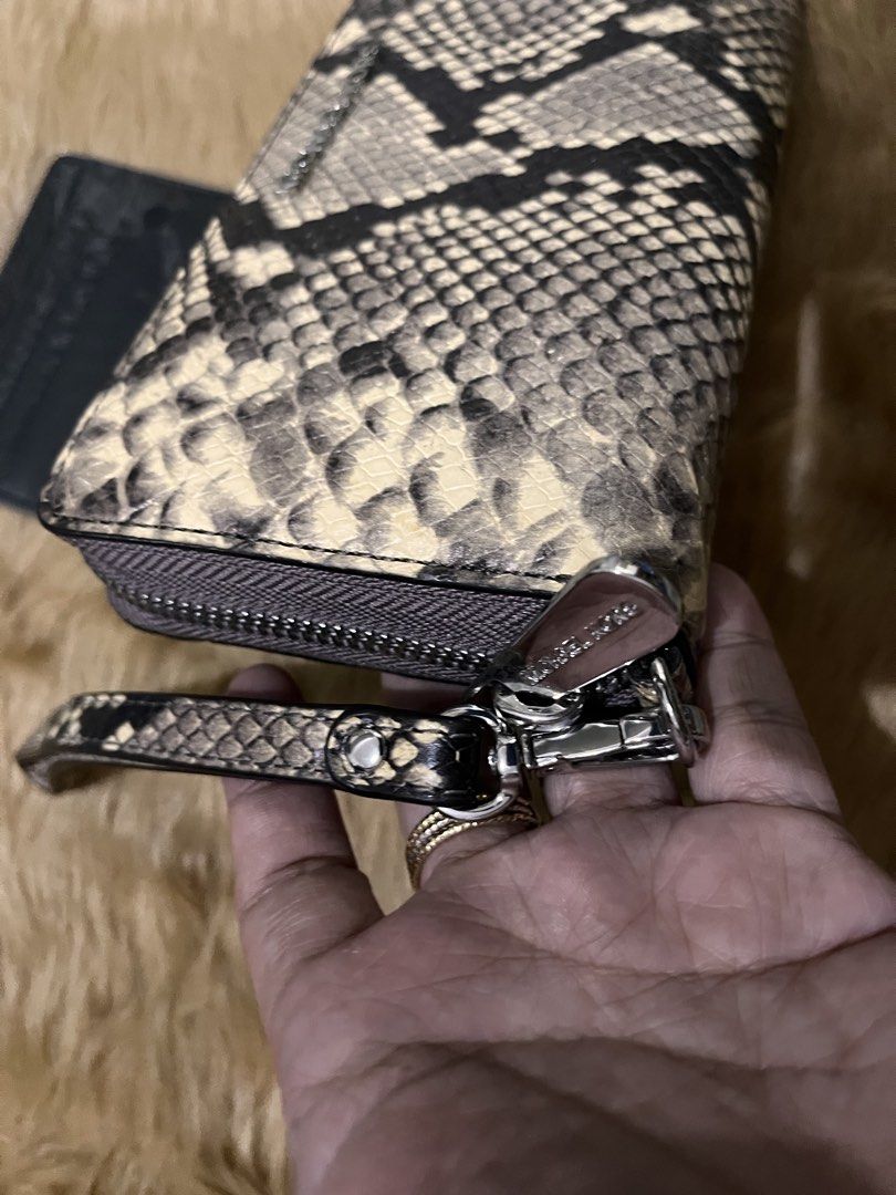 Michael Kors Snake Print Zip Around Wristlet Wallet (Category: Wallets & Card holders) located in Quezon City. Submitted by pickleballpaddle (Listing ID 1465626901, Image 2). Description: - Brand: Michael Kors ORIGINAL - Design: Cream and black snakeskin print with silver-toned hardware - Versatility: Includes a convenient detachable wrist strap - Interior: Cream lining with repeated logo print - Storage: Multiple card slots, slip compartments, a