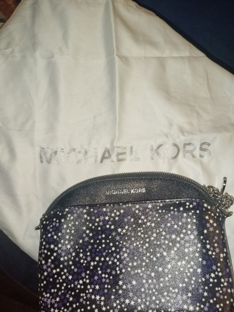 Michael Kors Starry Print Crossbody Bag (Category: Cross-body Bags) located in Baguio. Submitted by valenzuela.jc (Listing ID 1465698566, Image 3). Description: - Brand: Michael Kors - Style: Dome crossbody bag - Color/Design: Black with a purple and white star pattern - Features: Secure zip closure, branded fabric lining, and built-in internal card slots - Compact and lightweight size, perfect for traveling light - Includes original white Michae