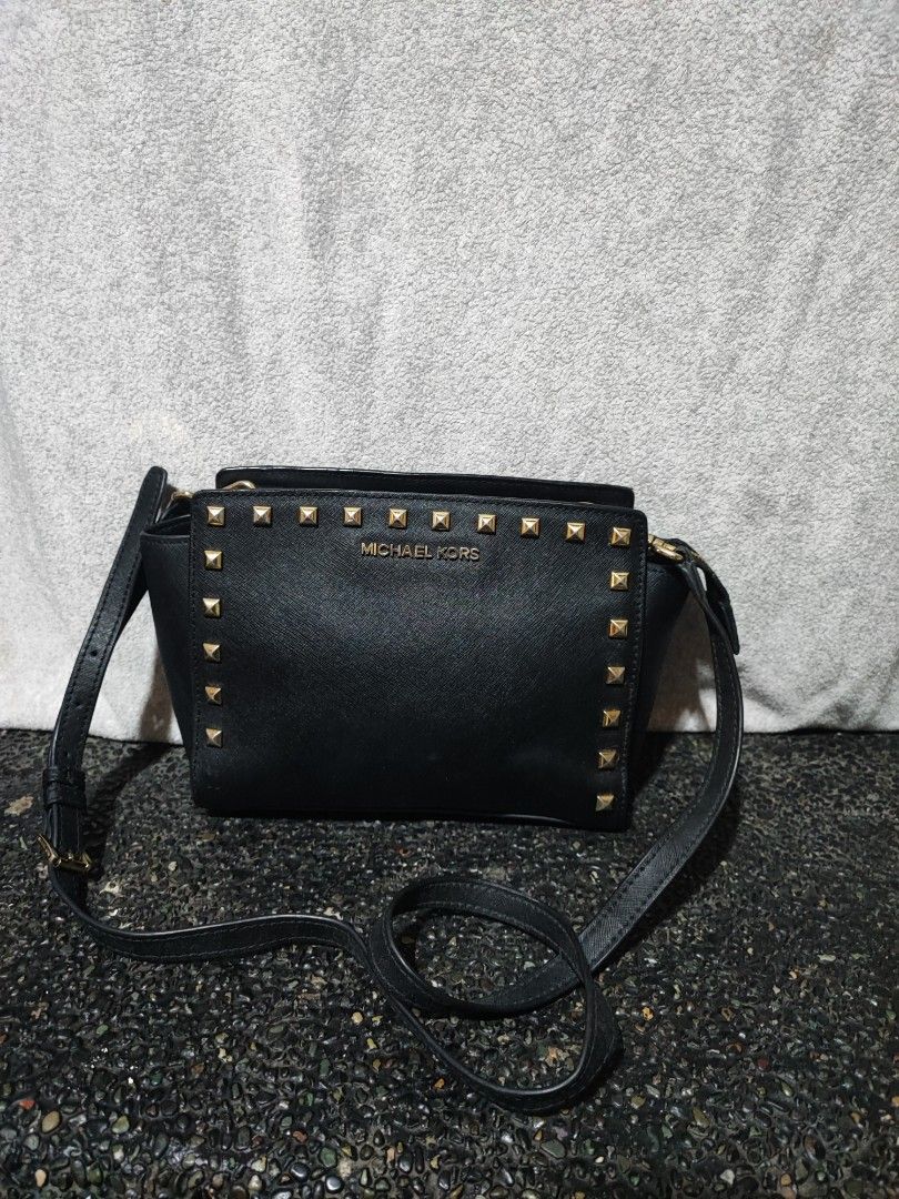 Michael Kors Studded Black Crossbody Bag (Category: Cross-body Bags) located in Baguio. Submitted by ozara.06 (Listing ID 1465699343, Image 1). Description: Michael Kors Small size May isang missing stud sa harap lower left At rubs sa bandnag end ng zipper 700 nlangs.