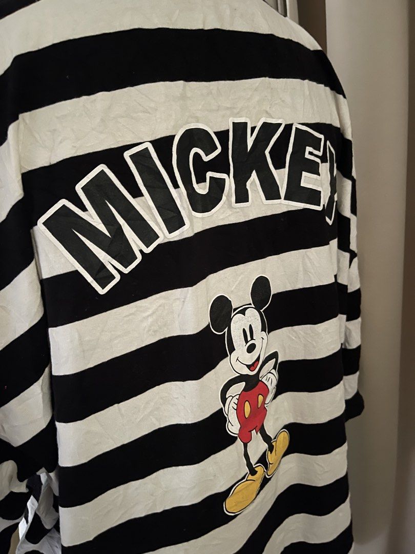 Mickey oversized embroid w/ backprint (Category: Shirts) located in Cainta. Submitted by zlove111 (Listing ID 1465758302, Image 3). Description: - Authentic Disney oversized polo shirt - Classic black and white stripes with a traditional polo collar - Small embroidered Mickey Mouse graphic on the left chest - Bold Mickey Mouse print and oversized MICKEY lettering on the upper back - Short sleeves with a relaxed and comfortable fit - Easy to style