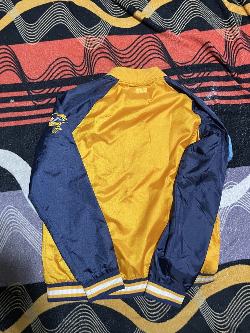 MLB Baltimore Orioles Varsity Jacket (Category: Coats, Jackets and Outerwear) located in Mandaue City. Submitted by anthony457 (Listing ID 1465644326, Image 2). Description: - Official MLB Baltimore Orioles satin bomber jacket - Eye-catching yellow body with contrast navy blue sleeves - Large team script across the chest and embroidered bird logo patch on the left sleeve - Classic snap button closure - Comfortable striped ribbed collar, cuffs, an