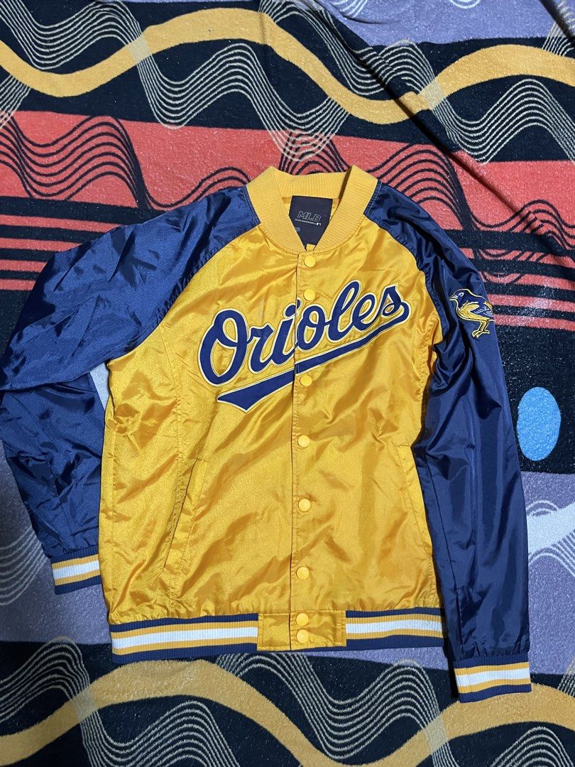 MLB Baltimore Orioles Varsity Jacket (Category: Coats, Jackets and Outerwear) located in Mandaue City. Submitted by anthony457 (Listing ID 1465644326, Image 1). Description: - Official MLB Baltimore Orioles satin bomber jacket - Eye-catching yellow body with contrast navy blue sleeves - Large team script across the chest and embroidered bird logo patch on the left sleeve - Classic snap button closure - Comfortable striped ribbed collar, cuffs, an