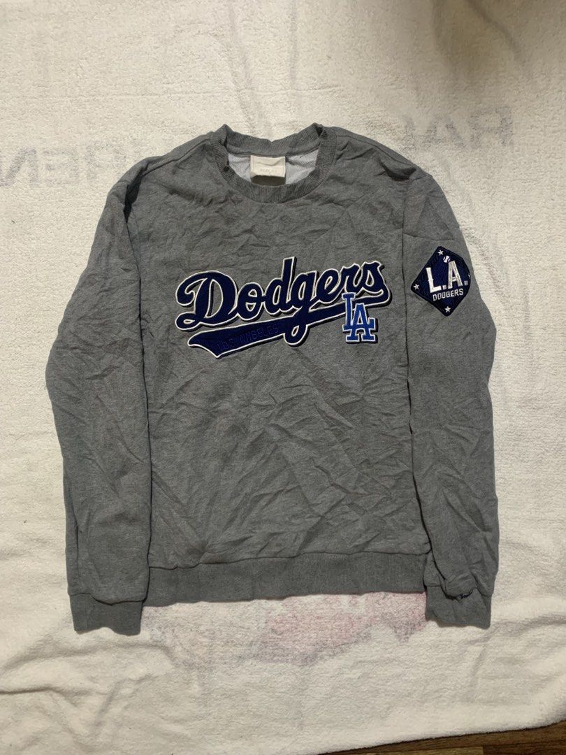 MLB Los Angeles Dodgers Grey Sweatshirt (Category: Coats, Jackets and Outerwear) located in Iloilo. Submitted by johnpullan30303 (Listing ID 1465710014, Image 1). Description: - Authentic grey Los Angeles Dodgers crewneck sweatshirt - Eye-catching large embroidered team script across the chest - Detailed embroidered 'L.A. Dodgers' diamond patch on the left sleeve - Official MLB batterman logo patch on the back collar - Cozy fleece lining inside f