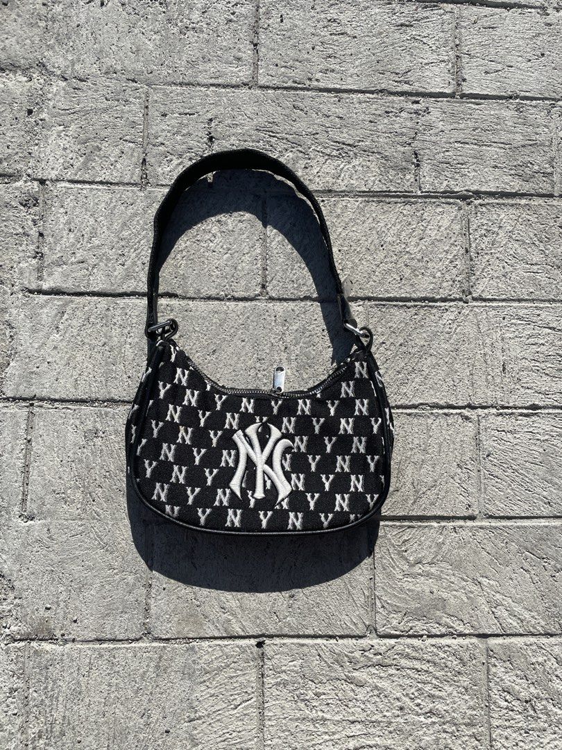 MLB New York Yankees Monogram Shoulder Bag Black White (Category: Shoulder Bags) located in Lucena. Submitted by riyizthriftz (Listing ID 1465704190, Image 1). Description: - Authentic New York Yankees monogram shoulder bag - Color: Black and white jacquard woven fabric with all-over NY print - Features: Large embroidered logo on the front, zip top closure, and silver-toned hardware - Design: Compact hobo shape with a comfortable black shoulder s