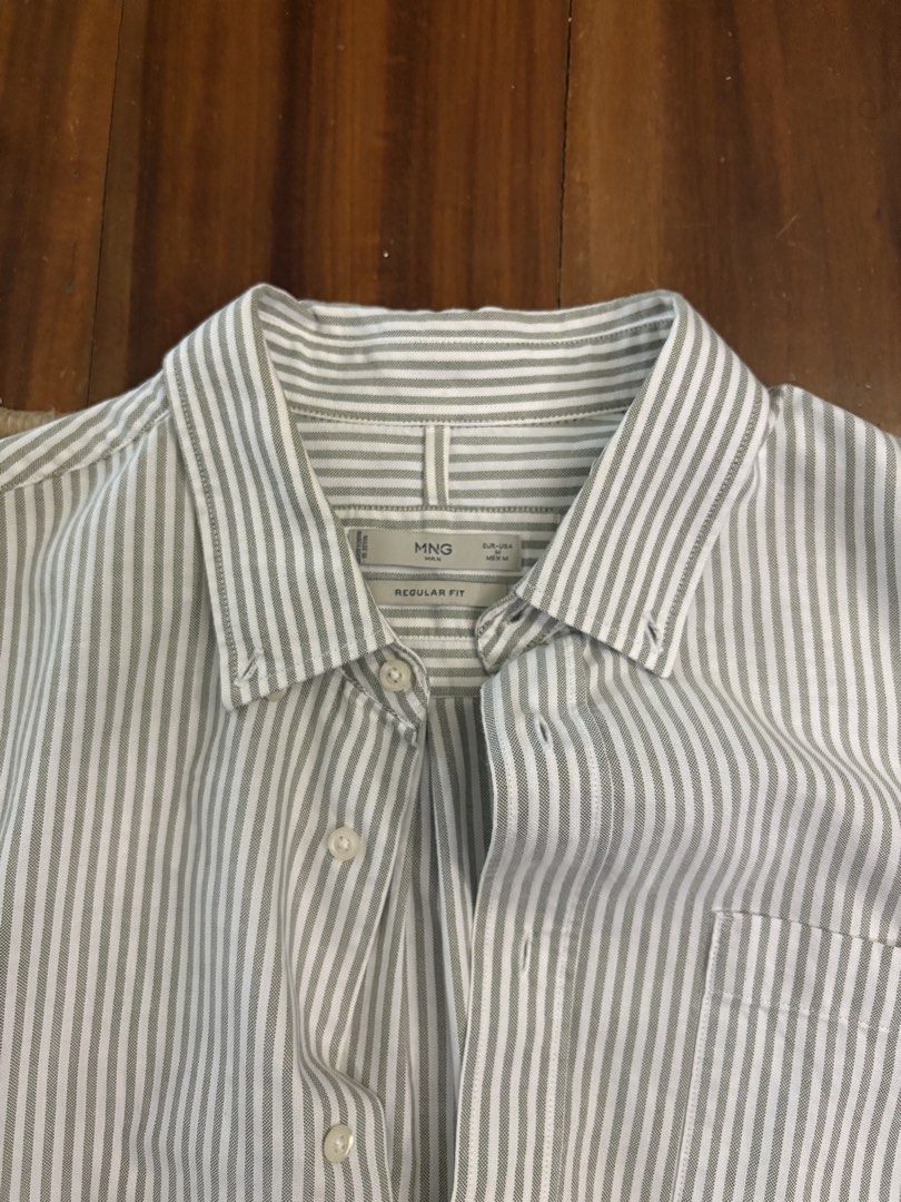 MNG Man Striped Long Sleeve Regular Fit Button-Down Shirt (Category: Formal Shirts) located in Paranaque City. Submitted by max_bully014 (Listing ID 1465609778, Image 2). Description: - Brand: MNG Man - Style: Long sleeve button-down shirt with classic collar - Color/Pattern: White with grey vertical stripes - Fit: Regular fit - Features: Single chest pocket, buttoned cuffs - Condition: Excellent, clean with no stains or tears - Ideal for: Work, 