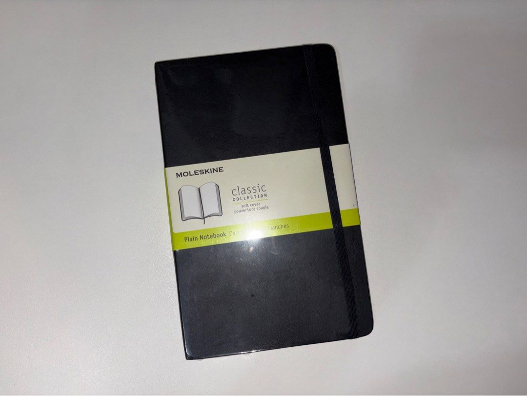 Moleskine Classic Collection Soft Cover Plain Notebook Black (Category: Stationery & School Supplies) located in Quezon City. Submitted by vvelcometomyshop (Listing ID 1465755035, Image 1). Description: - Brand: Moleskine - Condition: Brand new, unopened, and completely unused with original paper band - Cover: Soft black cover with secure elastic closure band - Pages: Plain, unlined pages ideal for sketching, journaling, or note-taking.