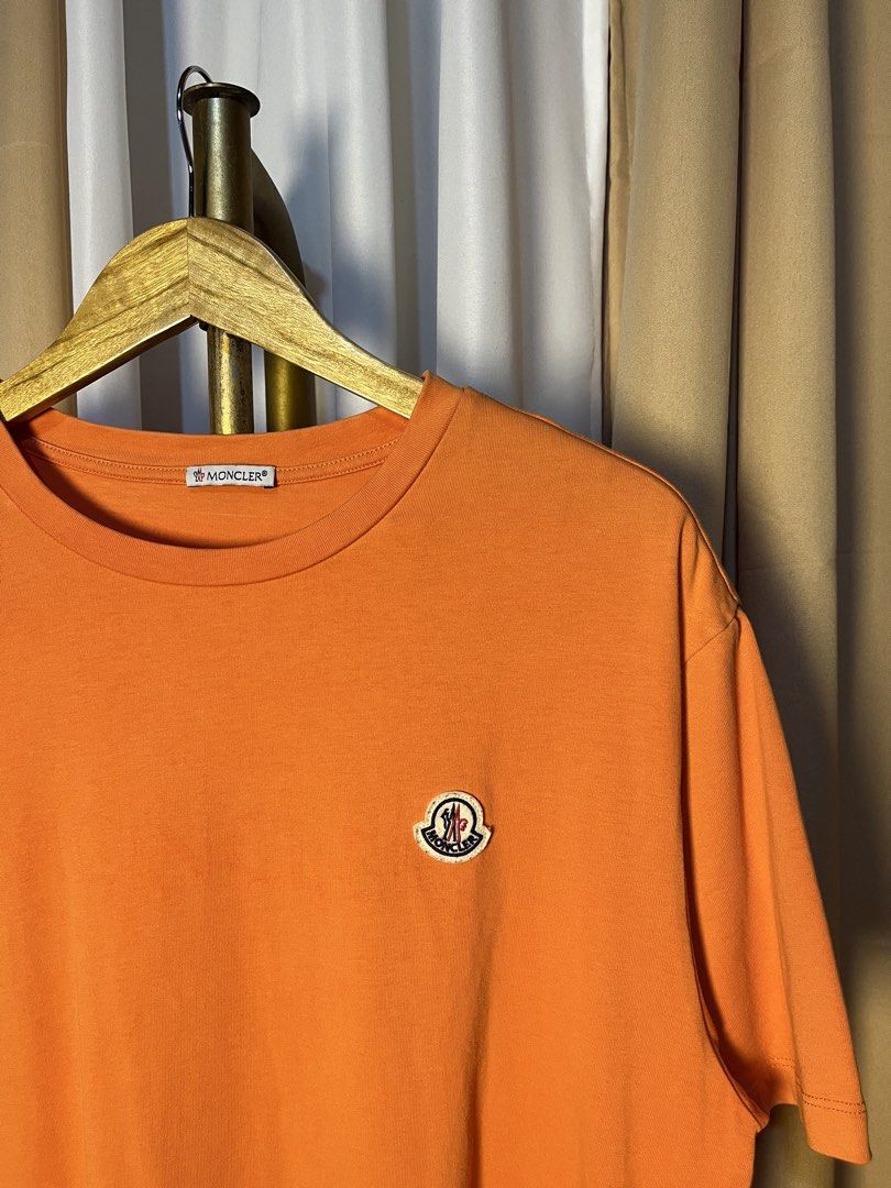 Moncler Orange T-Shirt Size L (Category: Tshirts & Polo Shirts ) located in Kidapawan. Submitted by azythrift (Listing ID 1465646643, Image 3). Description: - Brand: Moncler - Color: Bright Orange - Size: L (True to size) - Material: 100% soft & comfortable cotton - Fit: Standard fit with a classic round neckline - Details: Iconic embroidered logo patch on the left chest - Authenticity: Includes interior collar tag and QR code label - Condition: 