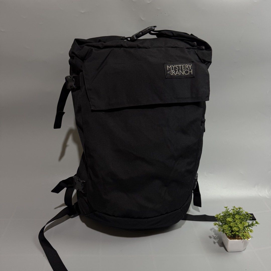 Mystery Ranch Black Backpack (Category: Backpacks) located in Bago City. Submitted by g___shop (Listing ID 1465689329, Image 3). Description: - Brand: Mystery Ranch - Color: Classic Black - Material: Clean, durable canvas - Closure: Secure roll-top with buckle - Comfort: Padded mesh shoulder straps - Fit: Multiple adjustment straps on sides and back - Branding: Signature logo patch on front flap - Condition: Excellent/Ready to use - Mode of Payme