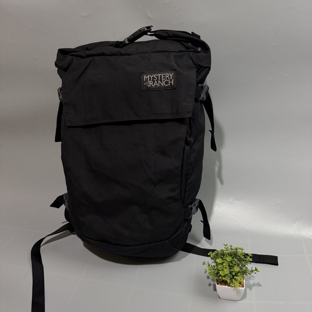 Mystery Ranch Black Backpack (Category: Backpacks) located in Bago City. Submitted by g___shop (Listing ID 1465689329, Image 2). Description: - Brand: Mystery Ranch - Color: Classic Black - Material: Clean, durable canvas - Closure: Secure roll-top with buckle - Comfort: Padded mesh shoulder straps - Fit: Multiple adjustment straps on sides and back - Branding: Signature logo patch on front flap - Condition: Excellent/Ready to use - Mode of Payme